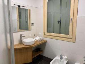 ein Badezimmer mit Waschbecken und Spiegel in der Unterkunft Appartamento 21 - Smart Apartment nel centro di Segusino, vicino le colline del Prosecco in Sequsino + 3 Fotos