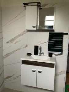 une salle de bains blanche avec un lavabo et un miroir dans l'établissement Rancho Girassol Casa de Campo em Extrema MG, à Extrema 41 autres photos