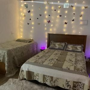 a bedroom with two beds and lights on the wall at Casa de campo in Extrema +35 photos