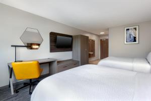 a hotel room with a bed and a desk and a tv at Holiday Inn Express & Suites Pittsfield-Lenox-Berkshires by IHG in Pittsfield
