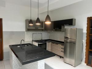 a kitchen with a stainless steel refrigerator and black counter top at Rancho Radical in Aquidauana
