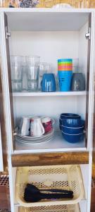 a cupboard with plates and bowls and other dishes at Casa rústica in Ica