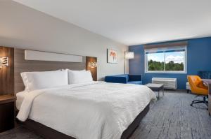 a hotel room with a large bed and a window at Holiday Inn Express & Suites Pittsfield-Lenox-Berkshires by IHG in Pittsfield