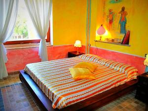 een slaapkamer met een groot bed met gele muren en een raam bij Villa Meridiana in Itri +40 foto's