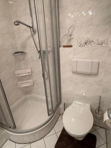 a white bathroom with a shower and a toilet at Ferienwohnung Reede 19 in Butjadingen