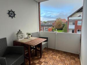 a small balcony with a wooden table and chairs at Ferienwohnung Reede 19 in Butjadingen