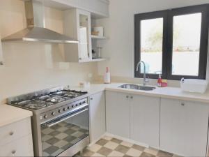 a white kitchen with a stove and a sink at Casapueblo Rent Cachagua CP 29 in Cachagua