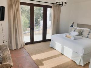 a bedroom with a large white bed and a sliding glass door at Casapueblo Rent Cachagua CP 29 in Cachagua +25 photos