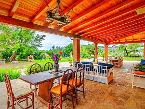 een patio met een houten pergola met een tafel en stoelen bij Villa Meridiana in Itri