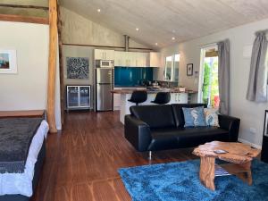 a living room with a couch and a kitchen at Mercury Orchard in Whenuakite