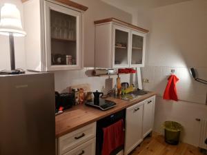 a kitchen with white cabinets and a wooden counter top at Gemütliche Wohnung in historischem Kulturdenkmal, 62qm in Hardegsen
