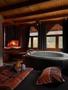 a living room with a tub and a fireplace at Krivaja River Retreat - Jacuzzi, Pool and Basketball 