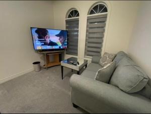 a living room with a couch and a flat screen tv at Budget Friendly Home in Oshawa