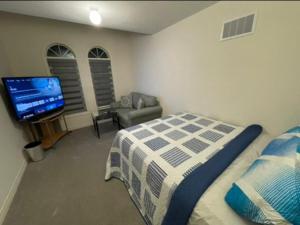 a bedroom with a bed and a flat screen tv at Budget Friendly Home in Oshawa
