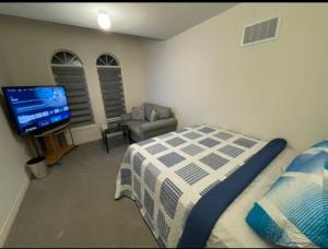 a bedroom with a bed and a flat screen tv at Budget Friendly Home in Oshawa +3 photos