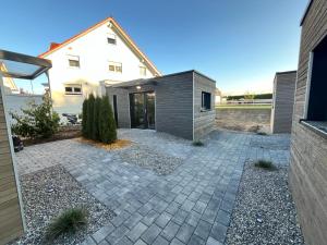 een achtertuin met een stenen terras en een huis bij Holiday & Stay, Tiny living in Fronreute