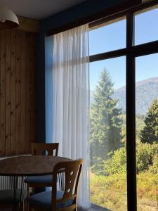 a dining room with a table and a large window at პანორამა გომარდული in Gomarduli