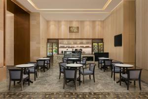 a restaurant with tables and chairs and a bar at Marriott Executive Apartments Bengaluru UB City in Bengaluru