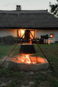einen Topf über einem Feuer vor einem Haus in der Unterkunft Balaton Cottage - Your Hide Away in Cserszegtomaj