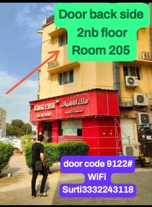 un hombre caminando frente a un edificio en Gulf Gateway Hostel, en Mascate