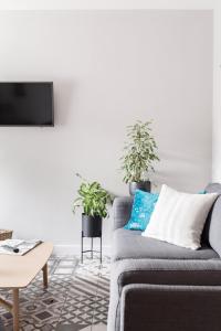 ein Wohnzimmer mit einem Sofa und zwei Topfpflanzen in der Unterkunft Meadow Cottage in Trumpington