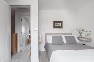 ein Schlafzimmer mit weißen Wänden und einem Bett mit zwei Kissen in der Unterkunft Meadow Cottage in Trumpington + 6 Fotos