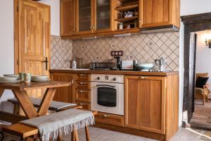 eine Küche mit Holzschränken, einem Herd und einem Tisch in der Unterkunft Balaton Cottage - Your Hide Away in Cserszegtomaj