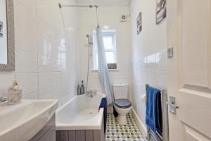 滨海绍森德Spacious Home by the Sea - Families, Contractors, Parking, WiFi, Sleeps 6, Long Stays - CLARK PROPERTY ESTATES的带浴缸、马桶和水槽的浴室