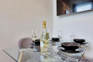 滨海绍森德Spacious Home by the Sea - Families, Contractors, Parking, WiFi, Sleeps 6, Long Stays - CLARK PROPERTY ESTATES的玻璃桌,带一瓶葡萄酒和玻璃杯