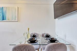 a dining room with a table with chairs and wine glasses at Bright & Luxury Home by the Sea, Great for Families & Contractors, Free Parking, Fast Wi-Fi, Guests 6, Ideal for Long Term Stays, Clark Property Estates in Southend-on-Sea