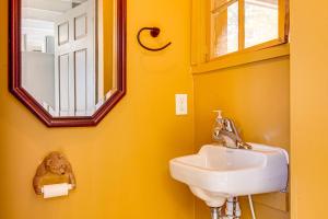 a yellow bathroom with a sink and a window at Direct Lake Access! Quiet Waukewan Retreat in Winona +20 photos