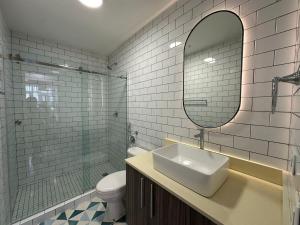 a bathroom with a sink and a mirror and a toilet at Stunning 1BR in Santa Ana Best Area in Panama City +16 photos