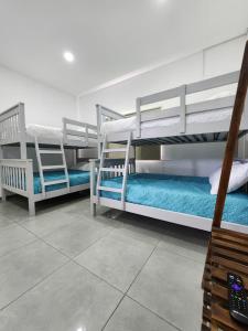 una habitación con tres literas en una habitación en Rancho Cali, Playa Las Hojas, El Salvador, en San Pedro Masahuat