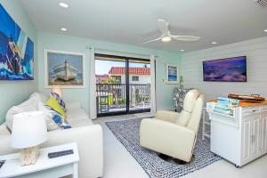 een woonkamer met een witte bank en stoelen bij 1BR ocean view condo on Sanibel Island Steps from the beach 3B3 in Sanibel