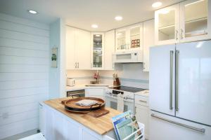 een keuken met witte kasten en een witte koelkast bij 1BR ocean view condo on Sanibel Island Steps from the beach 3B3 in Sanibel