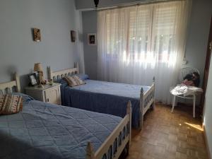 a bedroom with two twin beds and a window at La Casa de Oli in Chascomús