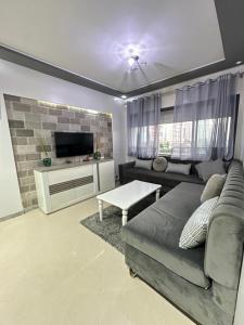 un salon avec un canapé et une télévision dans l'établissement Coastal vibes tanger, à Tanger
