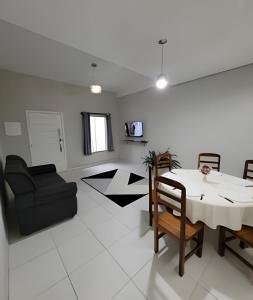 a living room with a table and a couch at Sobrado 6 amplo e confortável em condomínio in Corumbá
