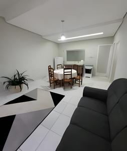 a living room with a table and a dining room at Sobrado 6 amplo e confortável em condomínio in Corumbá