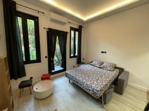 a bedroom with a bed and some windows at Chez Marlène bis, Vieil Antibes, Port Vauban in Antibes