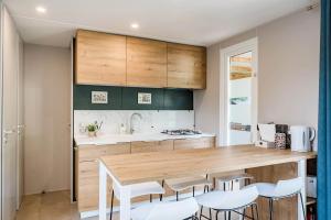 a kitchen with a wooden counter top and white chairs at Camping Papillon Kinrooi - 82 in Kinrooi +10 photos