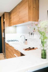 a kitchen with wooden cabinets and a white counter top at Camping Papillon Kinrooi - 87 in Kinrooi