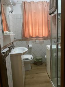 a bathroom with an orange shower curtain and a toilet at Alloggio Turistico LA TORRE in Acquapendente