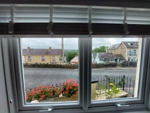 una finestra con vista su una strada e fiori di Cherry Cottage a Goodwick