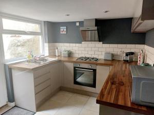 una cucina con lavello e fornello forno superiore di Cherry Cottage a Goodwick Altre 14 foto