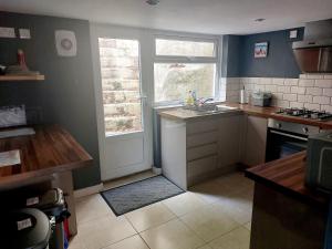 una piccola cucina con un lavandino e una finestra di Cherry Cottage a Goodwick