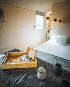 a bedroom with a bed and a wooden box on the floor at Camping Papillon Kinrooi - Pipowagen 2p terras in Kinrooi