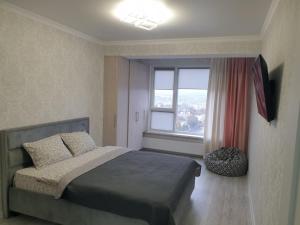 a bedroom with a bed and a large window at Botanica Aeroport in Chişinău
