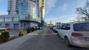 a street with cars parked on the side of a building at Botanica Aeroport in Chişinău