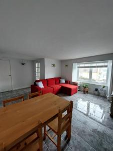 un soggiorno con un divano rosso e un tavolo di Cherry Cottage a Goodwick